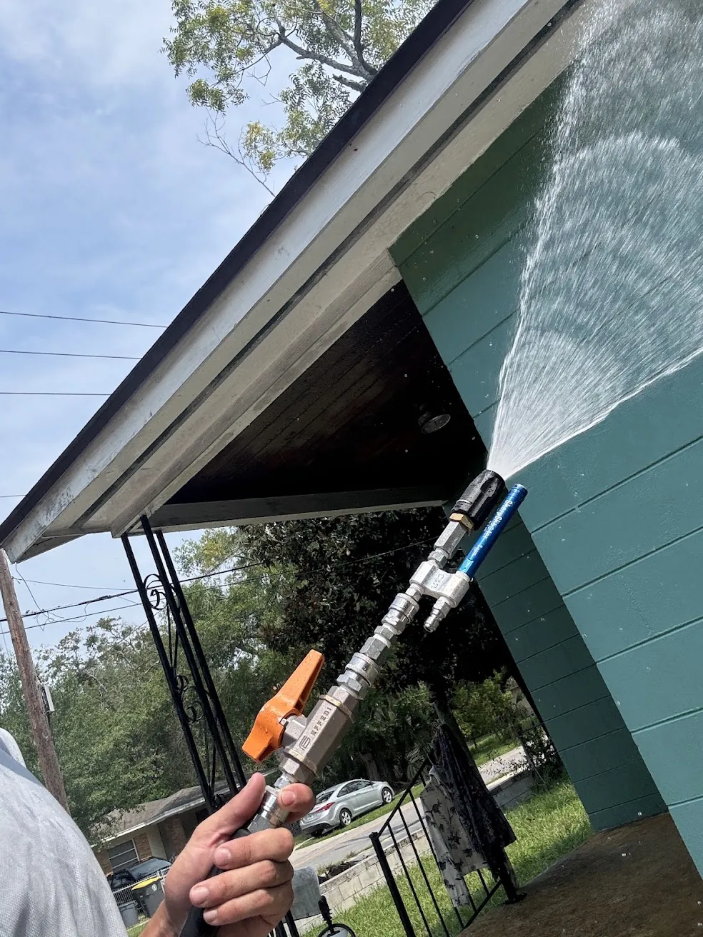Technician pressure washing built-up mold and grime off a home exterior wall in Jacksonville, FL